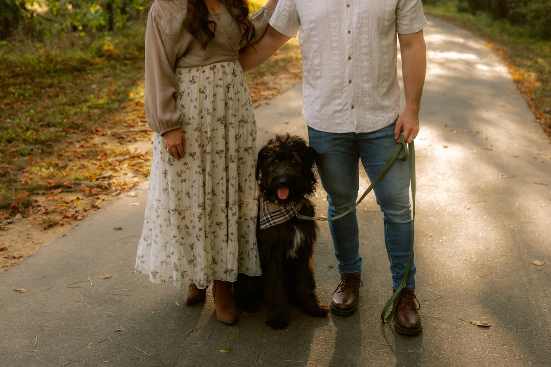 Couple walking outdoors with a doodle-type dog