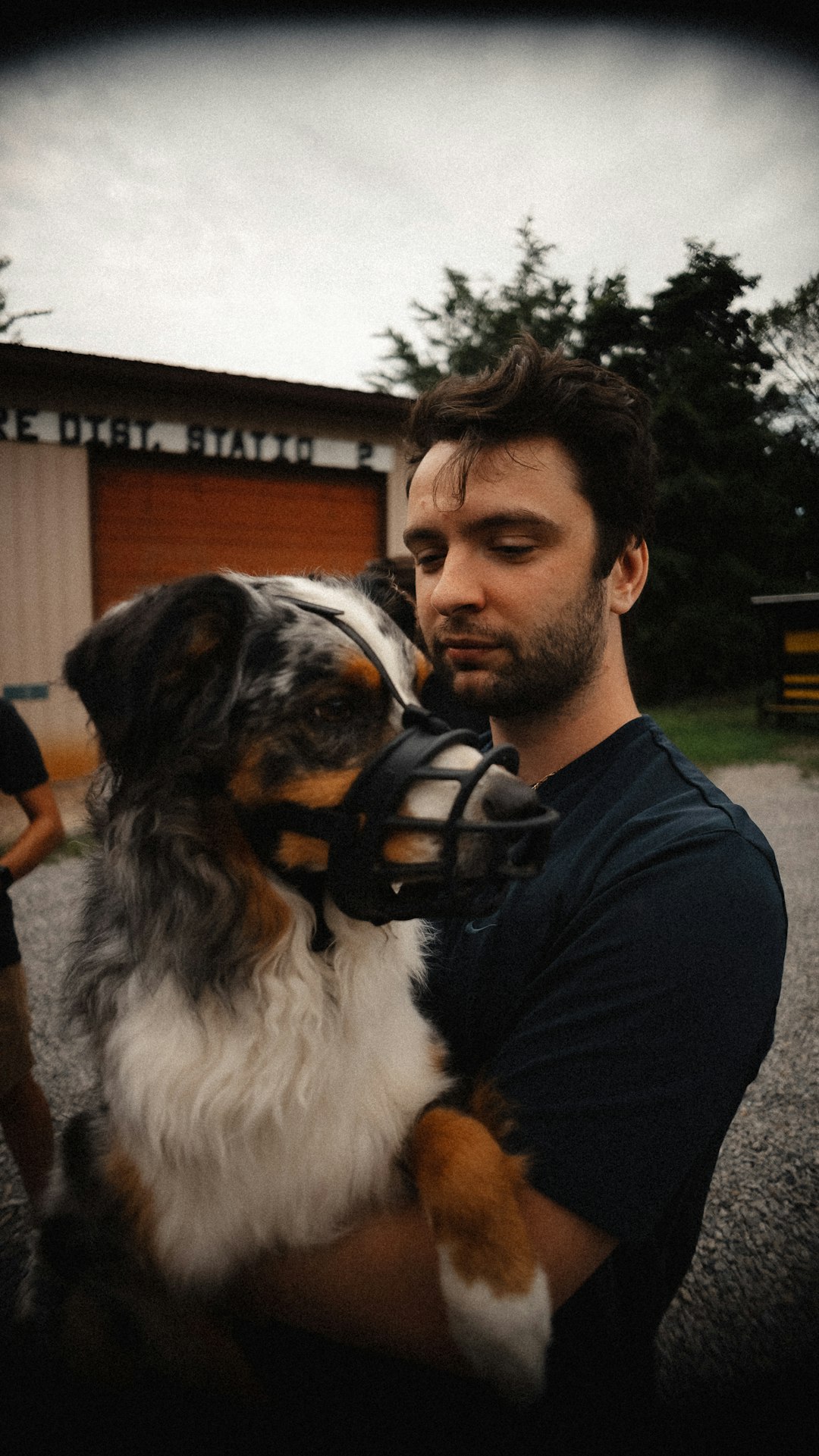 Handler with a dog wearing a muzzle safely outdoors